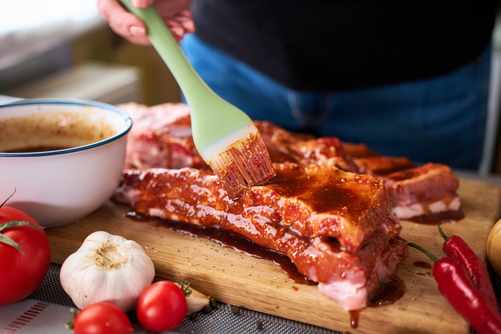 Brushing,Pork,Ribs,With,Marinade,Sauce,On,Wooden,Cutting,Board
