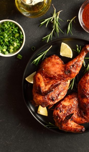 Grilled,Half,Chicken,With,Lemon,And,Rosemary,On,Plate,Over