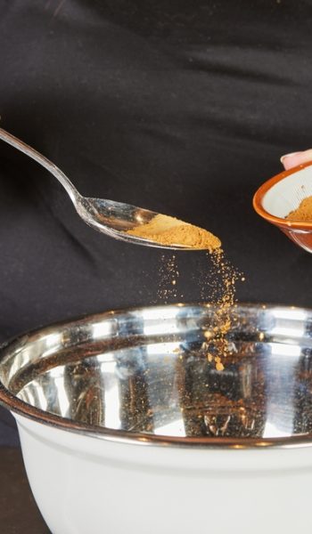 A,Person,Sprinkles,Cinnamon,Powder,From,A,Small,Bowl,Into